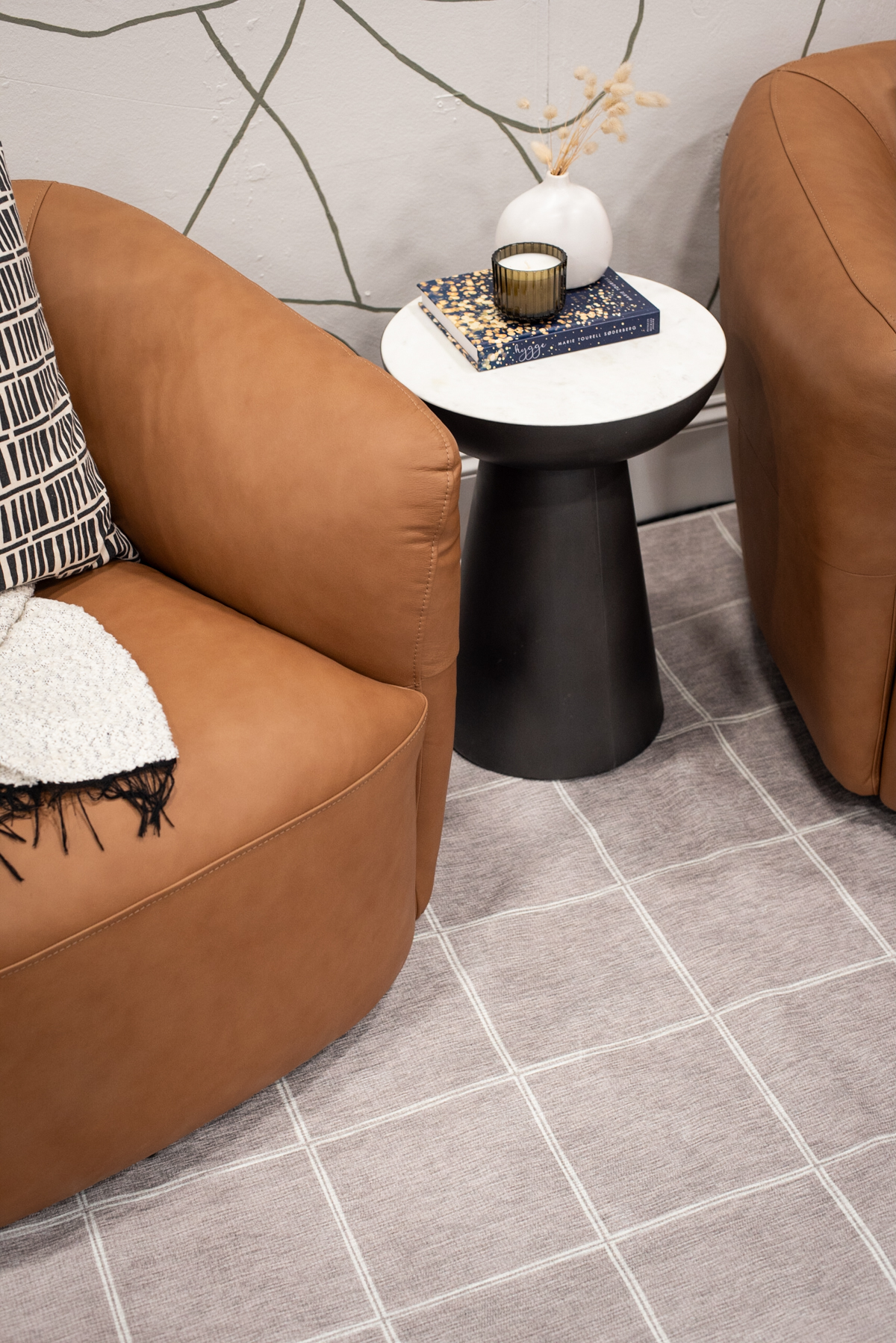 grid design rug with leather tub chairs for an upscale but cozy seating area