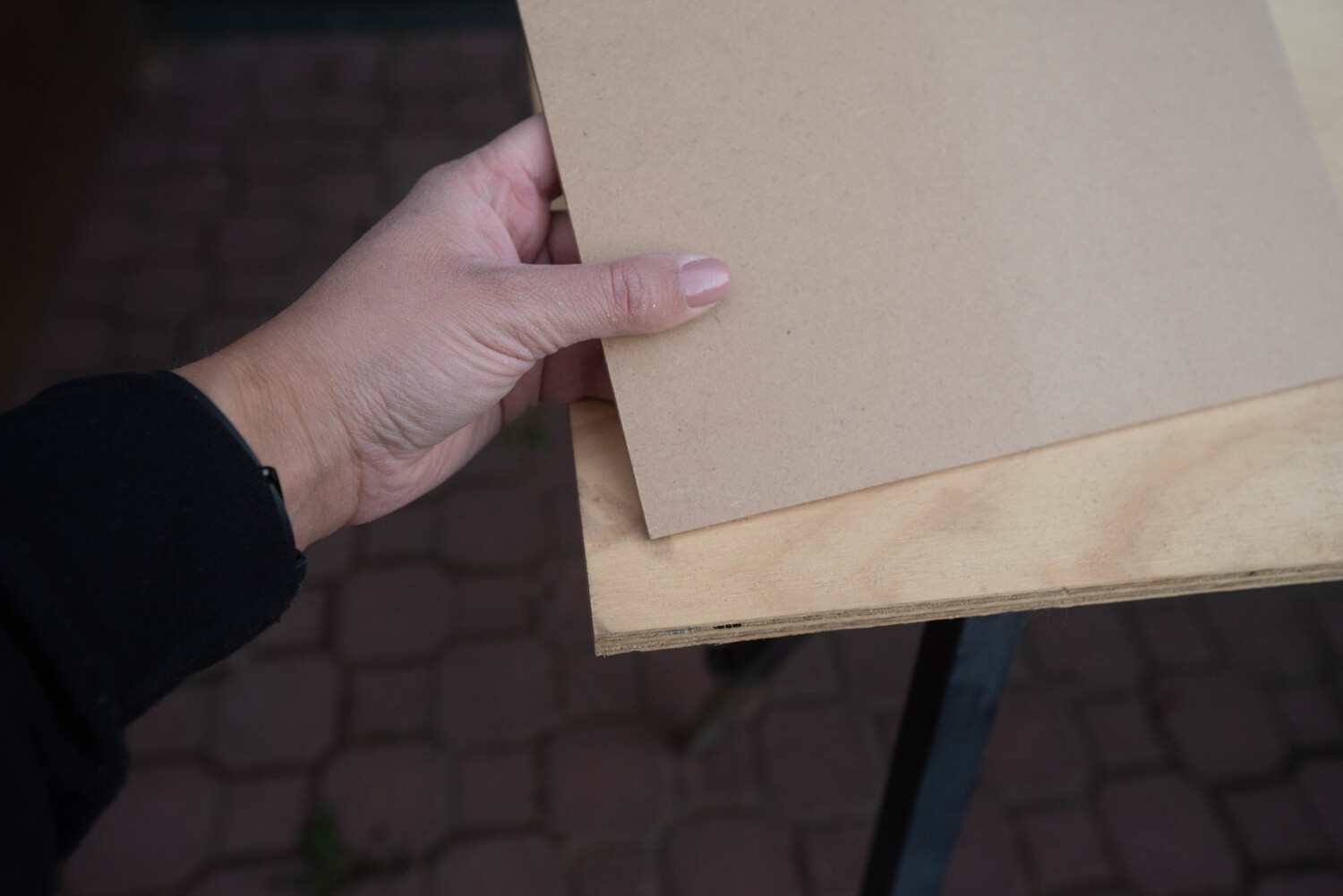 image shows mdf being held up next to plywood for comparison image in a blog post about choosing wood for diy projects