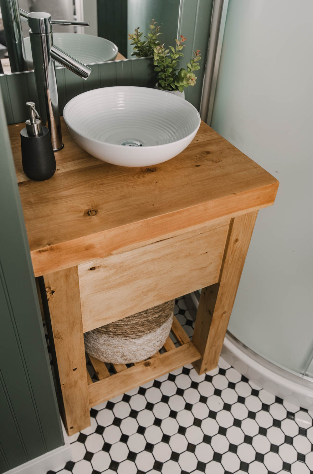 image of a rustic wood vanity built to fit a small nook with a vessel sink. image from blog post thats a introduction to the types of wood available for DIY projects