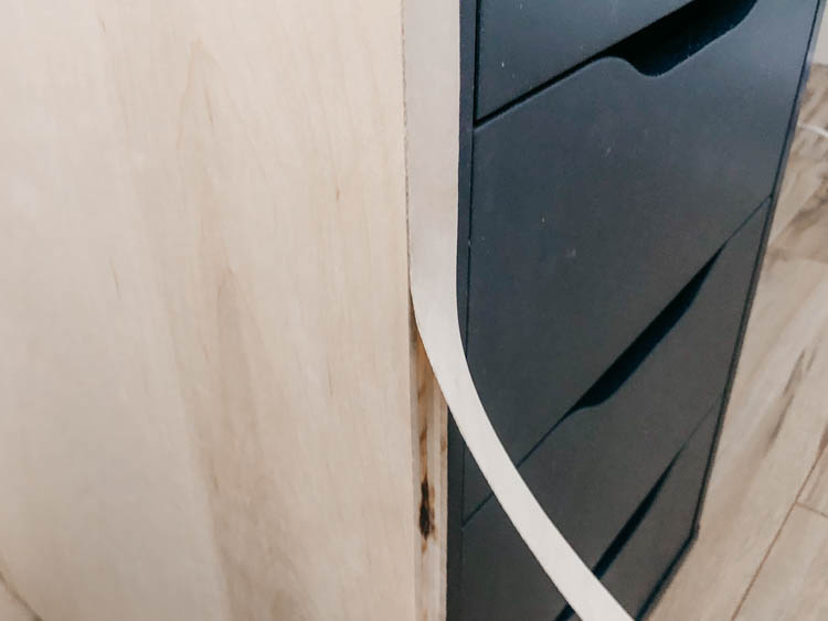 edge banding being applied to a plywood panel on a DIY desk project