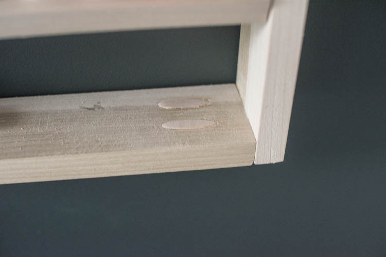 image shows screw holes filled with dowels for a diy shelf image in a blog post about choosing wood for diy projects