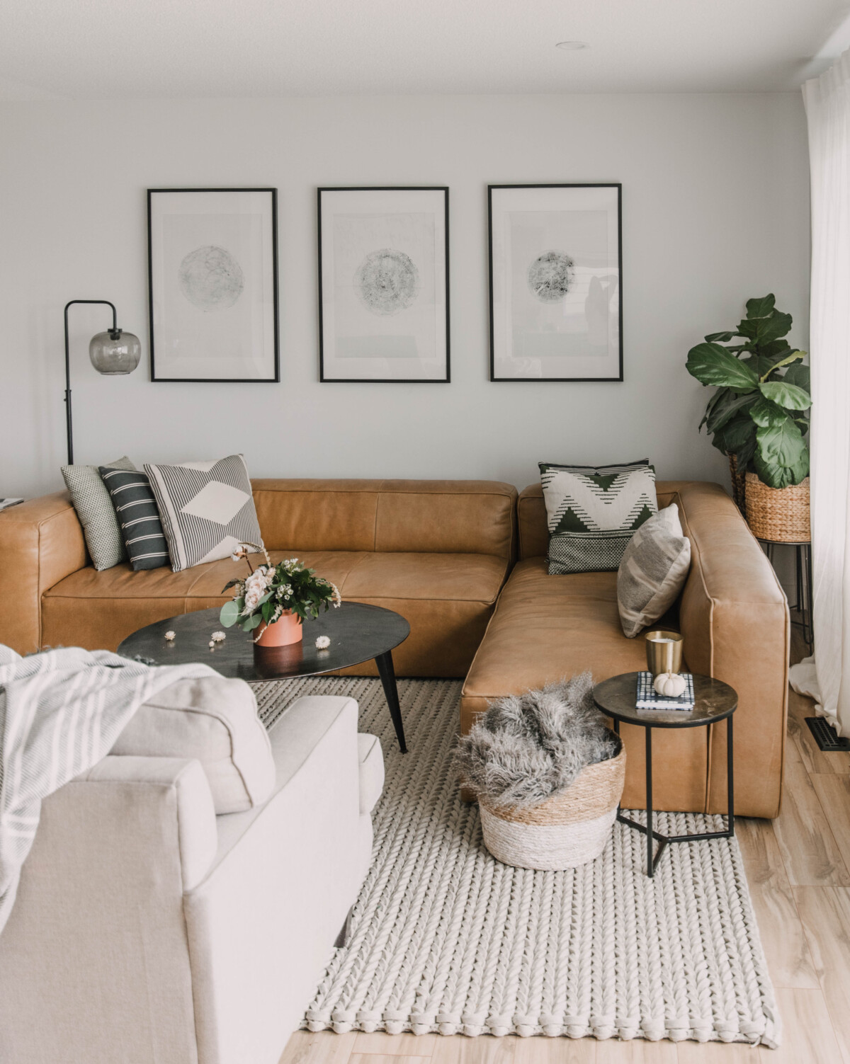 fiddle leaf figs to fill space behind sofa in a corner, height added to the shorter more affordable plants by placing on a plant stand or small table