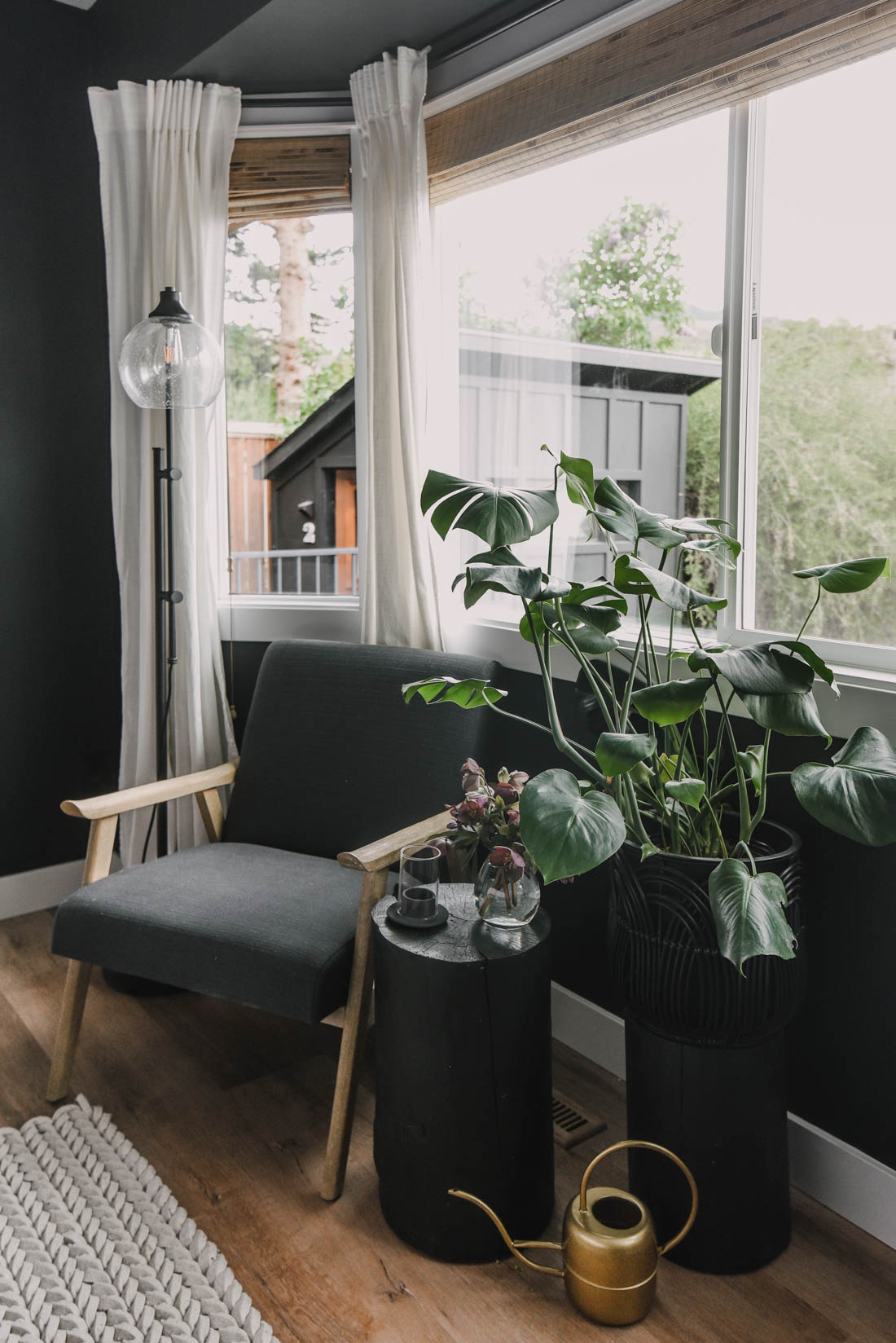Monstera potted with natural window light. Shown on a wooden plant stand for added height
