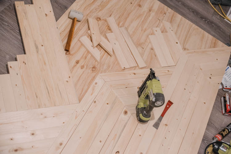 image of plywood panel backing being overlaid with 1x3 wood in a geometric pattern