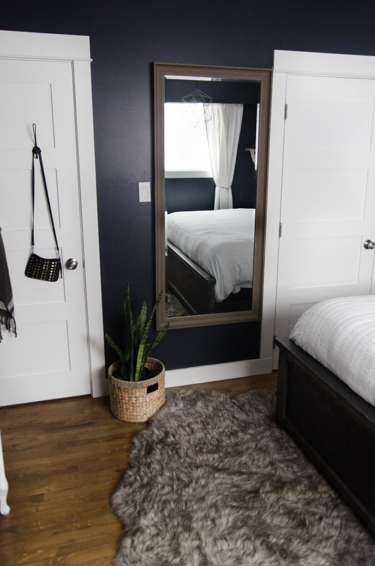 a snake plant potted in a basket in a dark bedroom